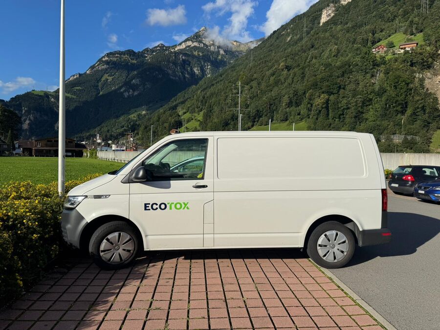 Ein Einsatzfahrzeug eines Kammerjaegers mit der Aufschrift Ecotox steht in Cham (6330, Kanton Zug), vor alpiner Landschaft geparkt.