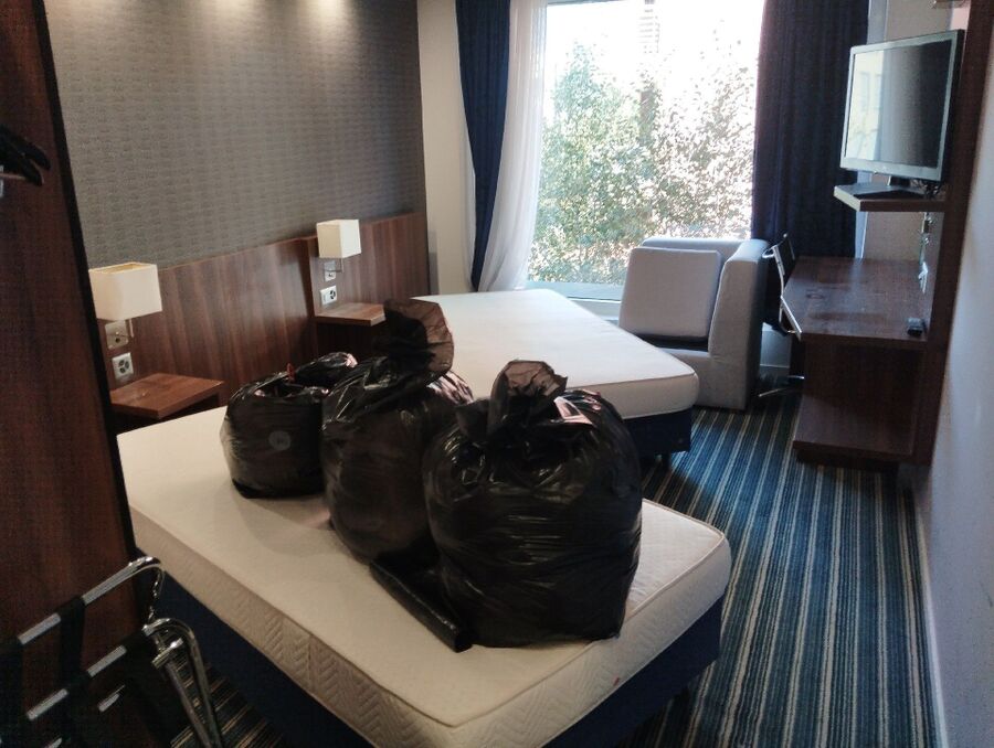 In einem Hotelzimmer in Walchwil (6318, Kanton Zug), stehen schwarze Saecke auf einem Bett, wodurch Spuren eines moeglichen Befalls verdeckt sein koennen.