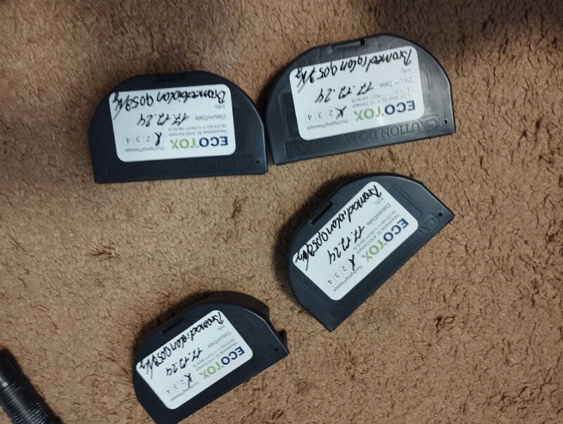 Auf einem Teppich in Cham (6330, Kanton Zug), liegen vier schwarze Koederboxen mit handschriftlicher Beschriftung zur Insektenbekaempfung.